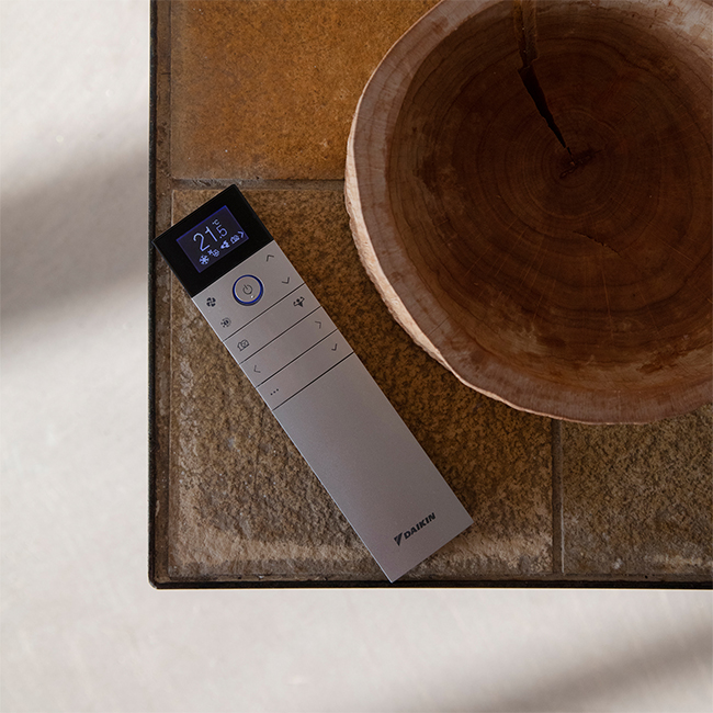 Witte Daikin Emura afstandsbediening: Minimalistisch, gebruiksvriendelijk ontwerp. Bediening voor temperatuur, fansnelheid, modus.