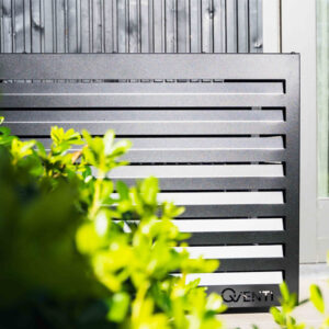 airco omkasting zwart achter een struik